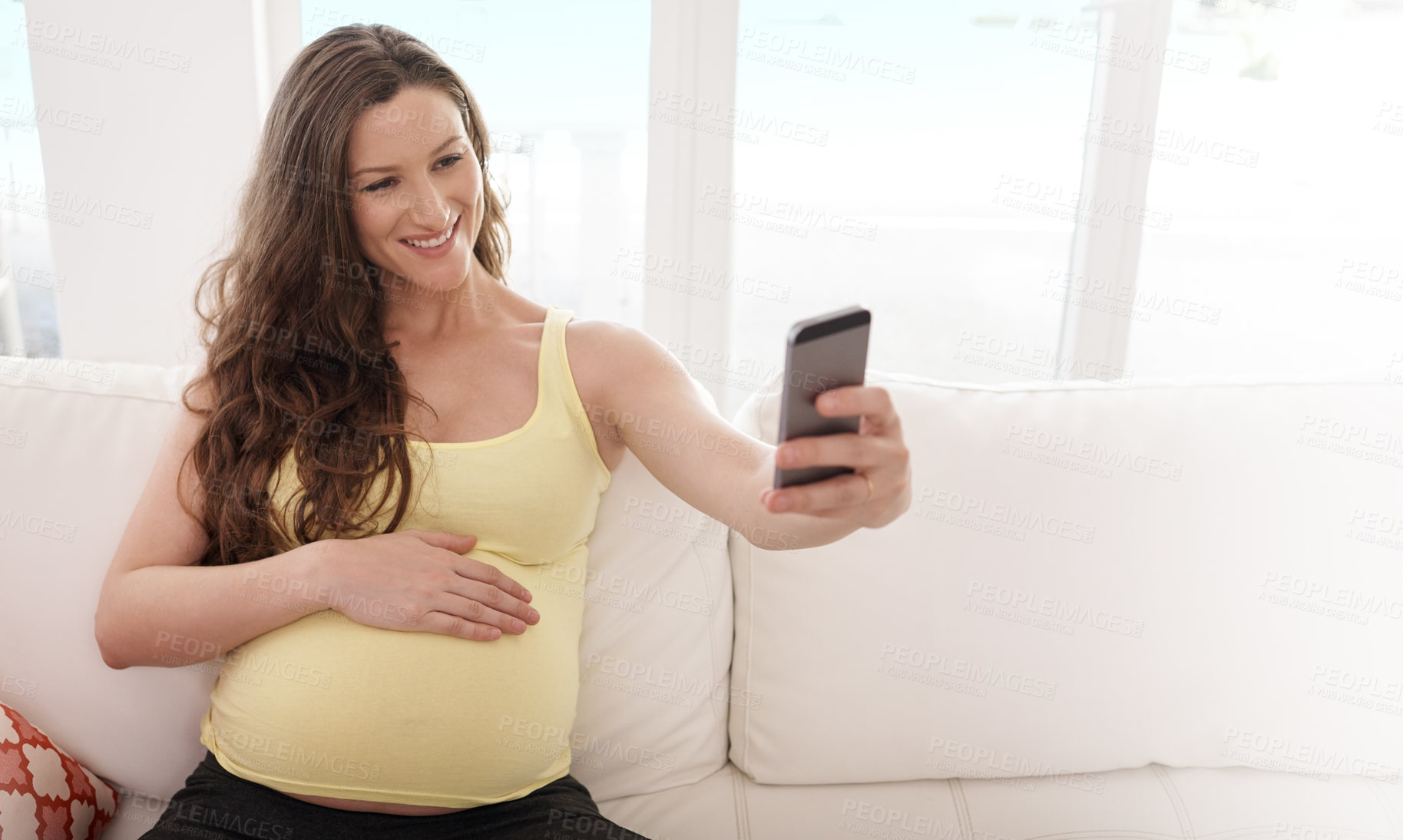 Buy stock photo Pregnant woman, selfie and happy on sofa in home, memory and touch belly for connection with baby. Person, mother and excited with expectation, stomach and smile for post on social network in house