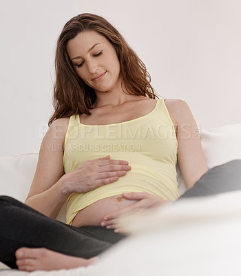 Buy stock photo Shot of a young pregnant woman in her living room