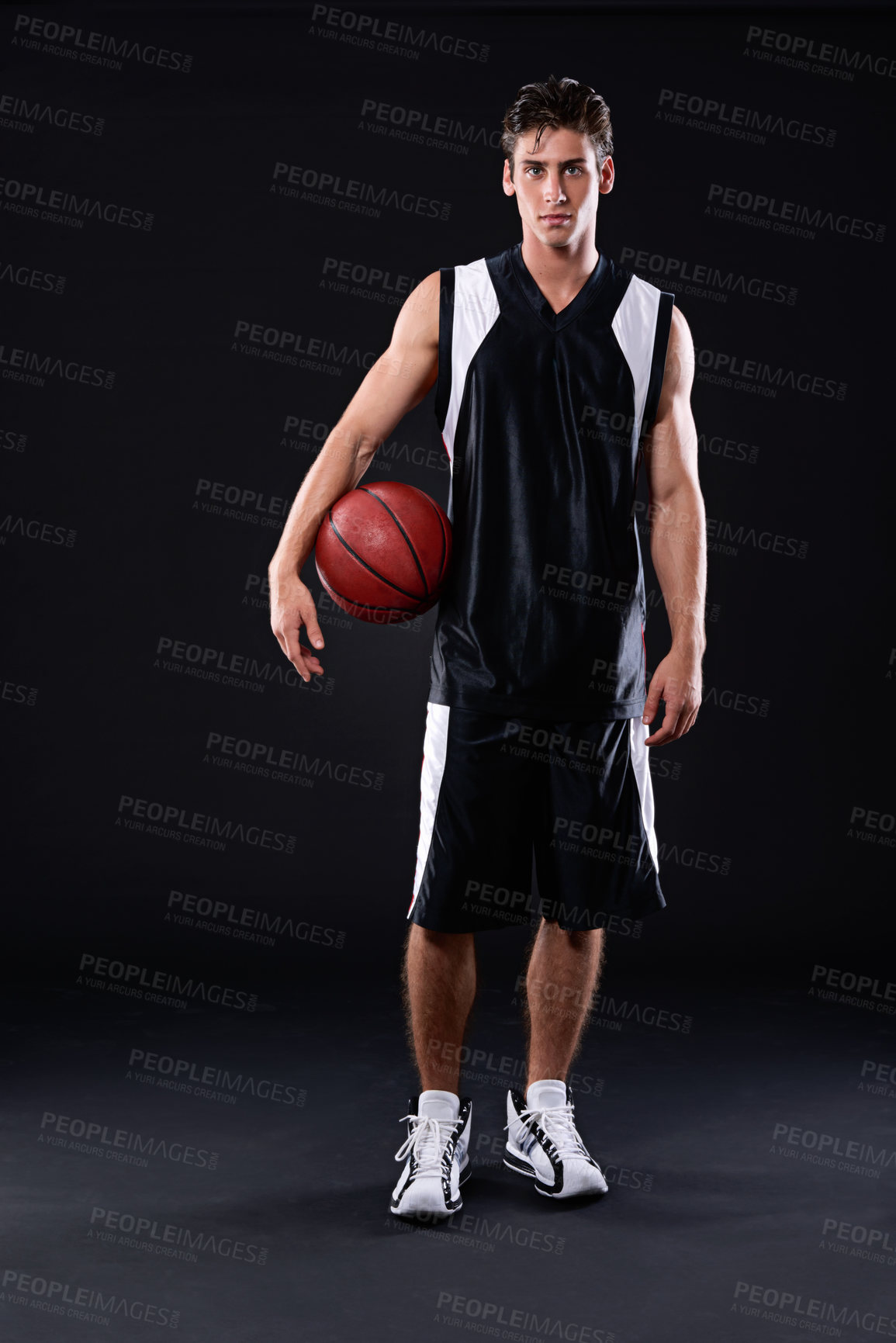 Buy stock photo Full length studio portrait of a basketball player standing with his ball against a black background