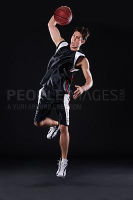Buy stock photo Full length shot of a male basketball player in action against a black background