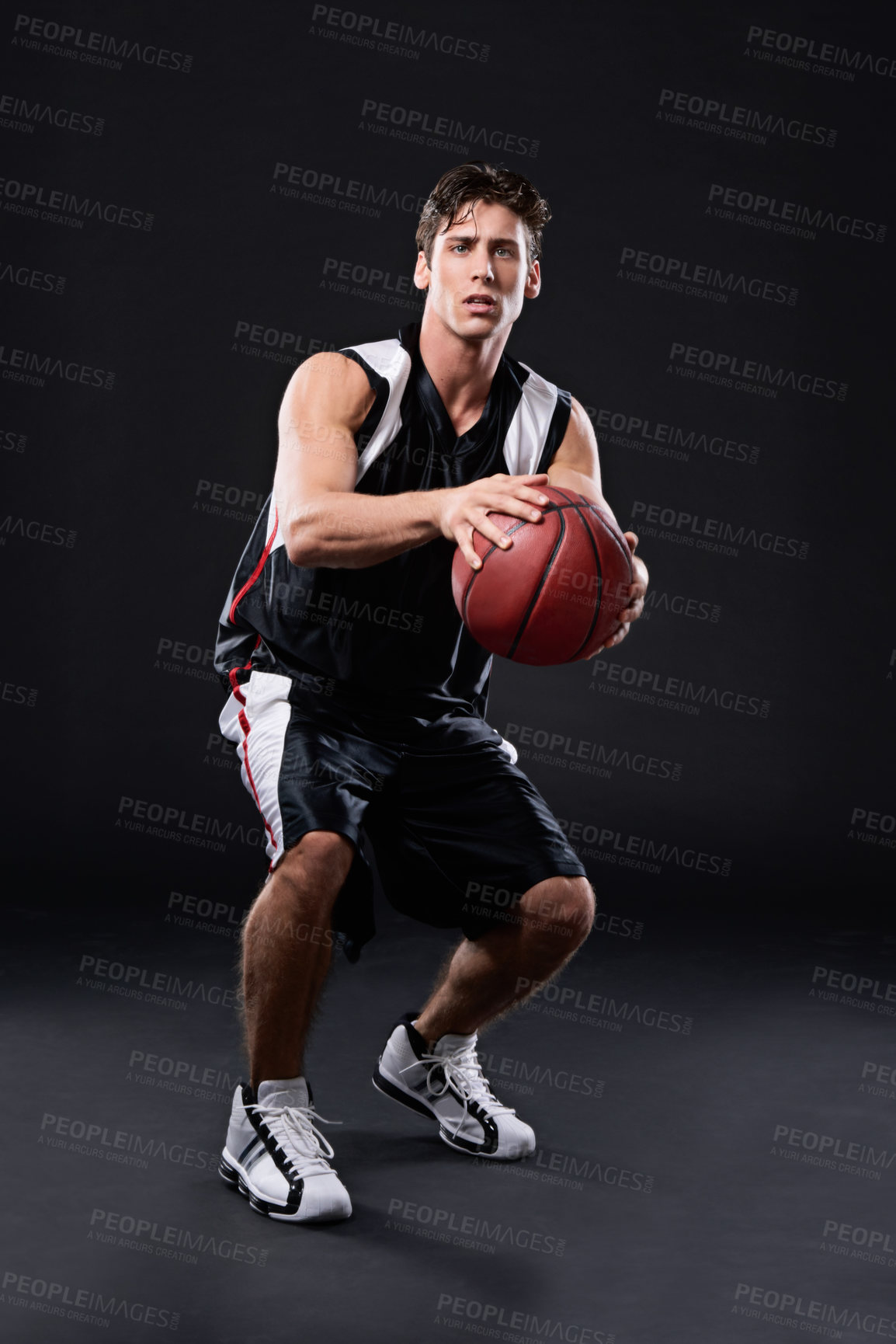 Buy stock photo Full length studio shot of a young male basketball player in action against a black background