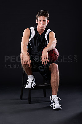 Buy stock photo Full length studio portrait of a male basketball player sitting with the ball under his arm