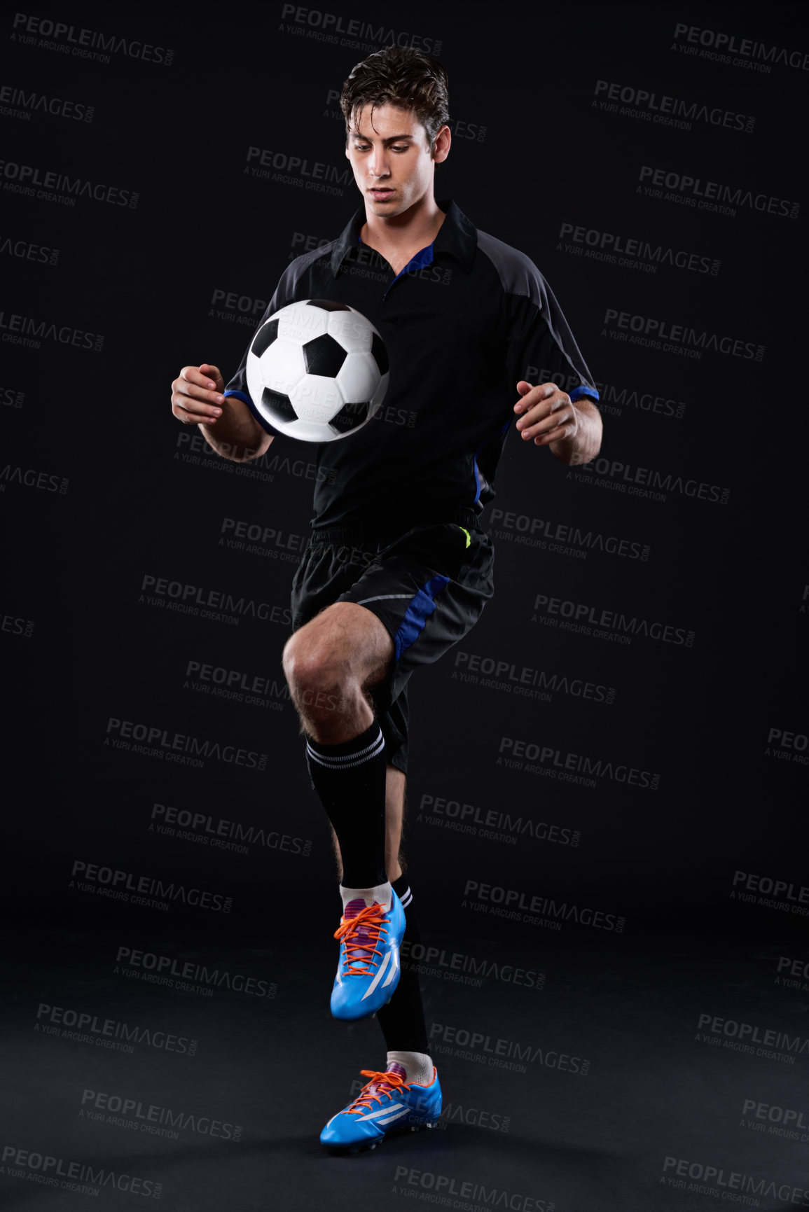 Buy stock photo Shot of a handsome soccer player isolated on black