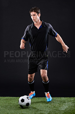 Buy stock photo Sports, ball and man football player on grass by black background for training, exercise or fitness. Lawn, field and male athlete with equipment for soccer practice, workout or match in studio.