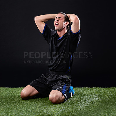 Buy stock photo Field, soccer player and man in grass, angry and lose in game, stress and upset on ground and outdoor. Black background, sad and athlete with hands, unhappy and person with shouting fail in football