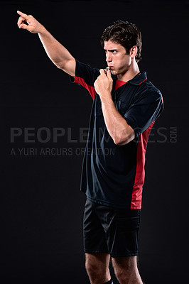 Buy stock photo Referee, pointing and blowing whistle in studio for decision in sport, hand for full time or stop. Male person, black background and review for penalty in game, call or sign with warning at night