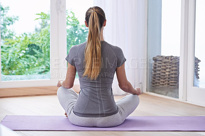 Buy stock photo A young woman meditating at home