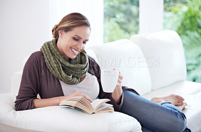 Buy stock photo Happy, woman and reading book with coffee on sofa for story, novel or hobby in living room at home. Lady, fiction books and drinking cup of tea for literature, knowledge or comfortable break on couch