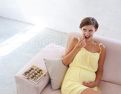 Buy stock photo Pregnant woman, eating chocolate and relax in home, alone and happy for delicious pregnancy craving. Good mood, comfort food and candy dessert for maternity, snack and sweet tooth satisfaction