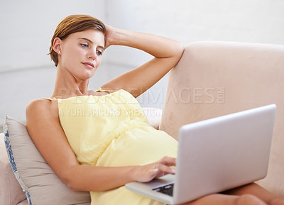 Buy stock photo Thinking, pregnant and woman on laptop in house living room for childcare website, information and reading. Vision, ideas and relax person on home sofa with technology, research and pregnancy blog