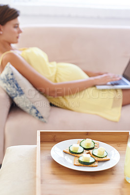 Buy stock photo Pregnant woman, food and laptop on sofa with healthy, nutrition or wellness for lunch or snack in living room. Person, meal or brunch and crackers on couch for remote work, relax and internet at home