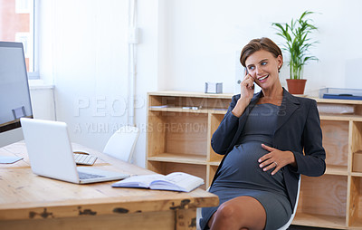 Buy stock photo A pregnant businesswoman having an enjoyable conversation on the phone at her office desk