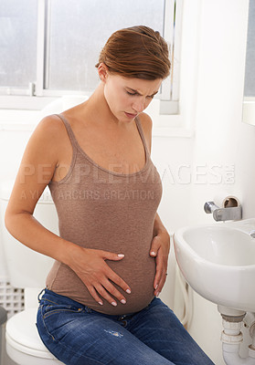 Buy stock photo Pregnant, woman and pain on toilet with bathroom, stomach and distress in labor or cramps. Female person, anxiety and discomfort in home with tired, antenatal health and wellness as mother to be