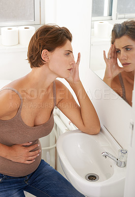 Buy stock photo Pregnant, female person and headache in bathroom with stomach, pain and distress in labor or cramps. Woman, anxiety and discomfort in home with tired, antenatal health and wellness in maternity