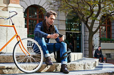 Buy stock photo Relax, city and smile with man, smartphone and bicycle with adventure and travel with internet and social media. Commute, outdoor and New York with guy and cellphone with connection and digital app