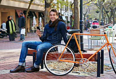 Buy stock photo Portrait, outdoor and smile with man, cellphone and bicycle with adventure and travel with internet and social media. Person, bench or New York with digital app and smartphone with connection or meme
