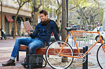 Buy stock photo Happy, city and smile with man, tablet and bicycle with adventure and digital app with email and social media. Person on bench, outdoor and New York with guy and technology with connection and typing