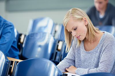 Buy stock photo Lecture hall, thinking and woman with knowledge, student or college with academy or education. Person, writing or girl in classroom with test or learning with studying or creativity with info or exam