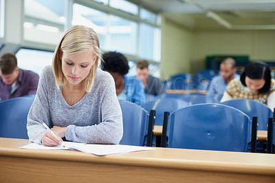 Buy stock photo Lecture, woman and student writing, focus and education for development, knowledge and learning. Female person, young people or group in a room, notes and ambition at university, scholarship and test
