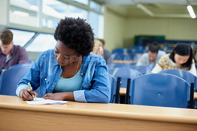 Buy stock photo Writing, college and black woman student in classroom studying for test, exam or assignment. Education, university and African female person working on project with knowledge in lecture hall.