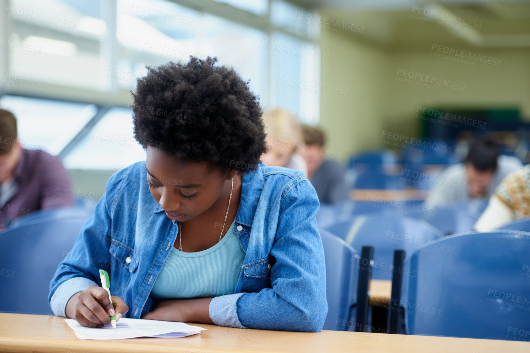 Buy stock photo Writing, university and black woman student in classroom studying for test, exam or assignment. Education, college and female person working on project with knowledge in lecture hall for learning.