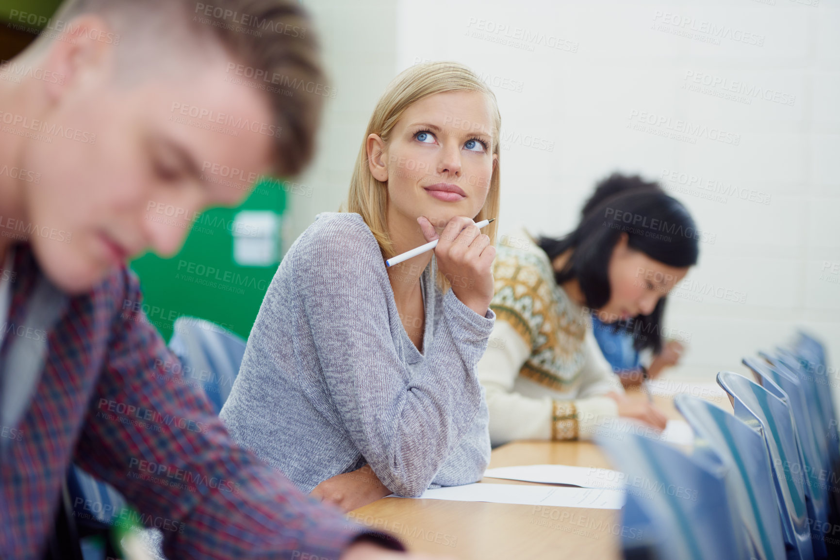 Buy stock photo Student, thinking and exam writing in university classroom for education assessment for learning, answer or scholarship. Female person, pencil and thoughts in lecture hall or idea, school or London