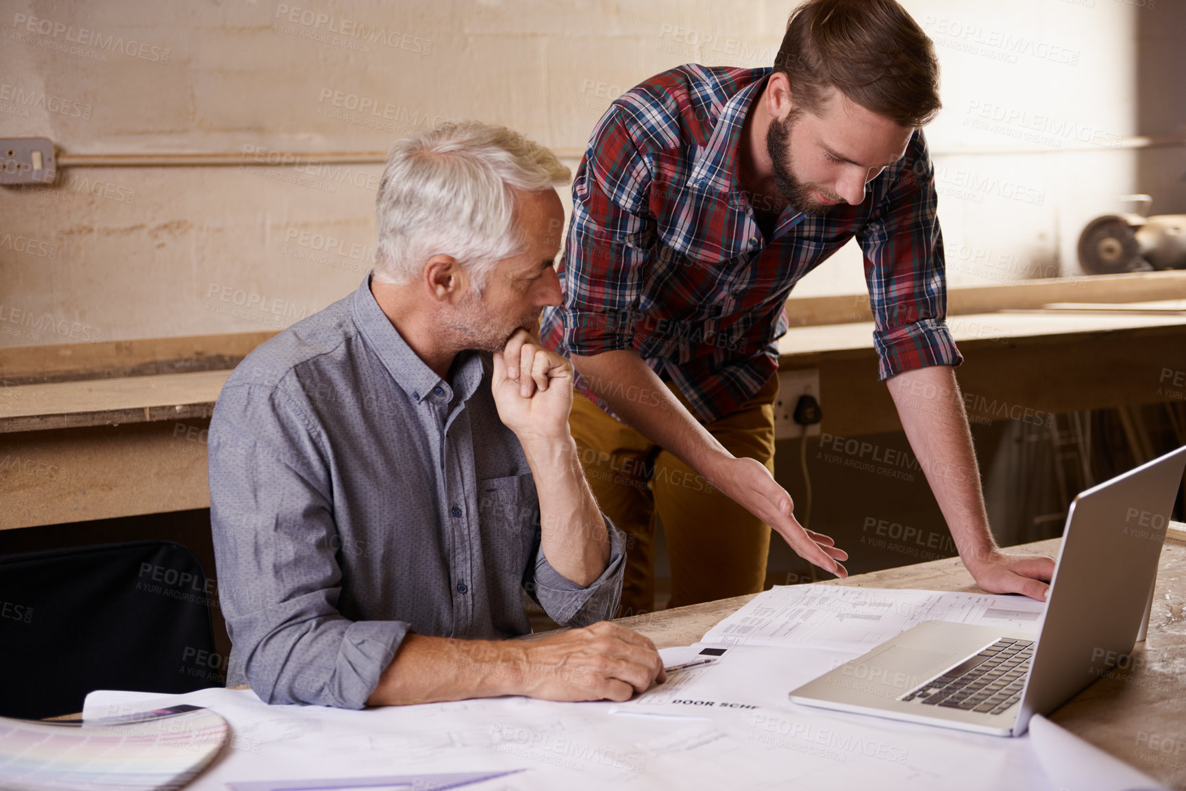 Buy stock photo Architecture, collaboration and father and son with blueprint in workshop for building construction on laptop. Senior engineer, men and paperwork of trainee or apprentice working on design and plan.