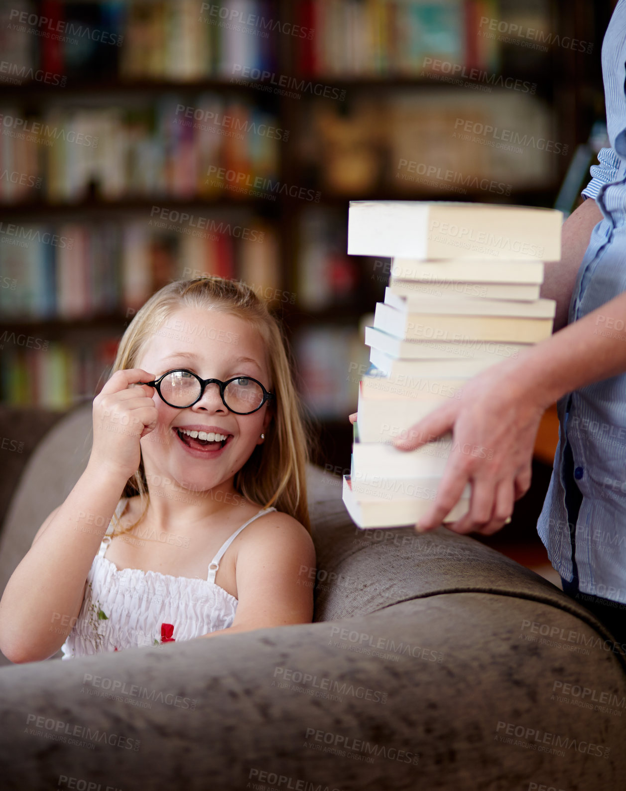 Buy stock photo Smile, stack of books and kid in library, learning and relax, studying homework knowledge on couch. School, woman and girl child with glasses in bookstore together with story,  and education on sofa.