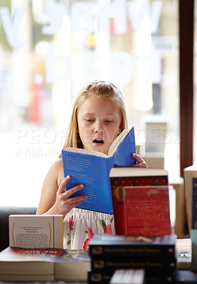 Buy stock photo Shock, stack of books and child in bookshop, learning and studying, homework and knowledge in store. School, surprise face and girl in bookstore with story, fantasy and education in shop reading.