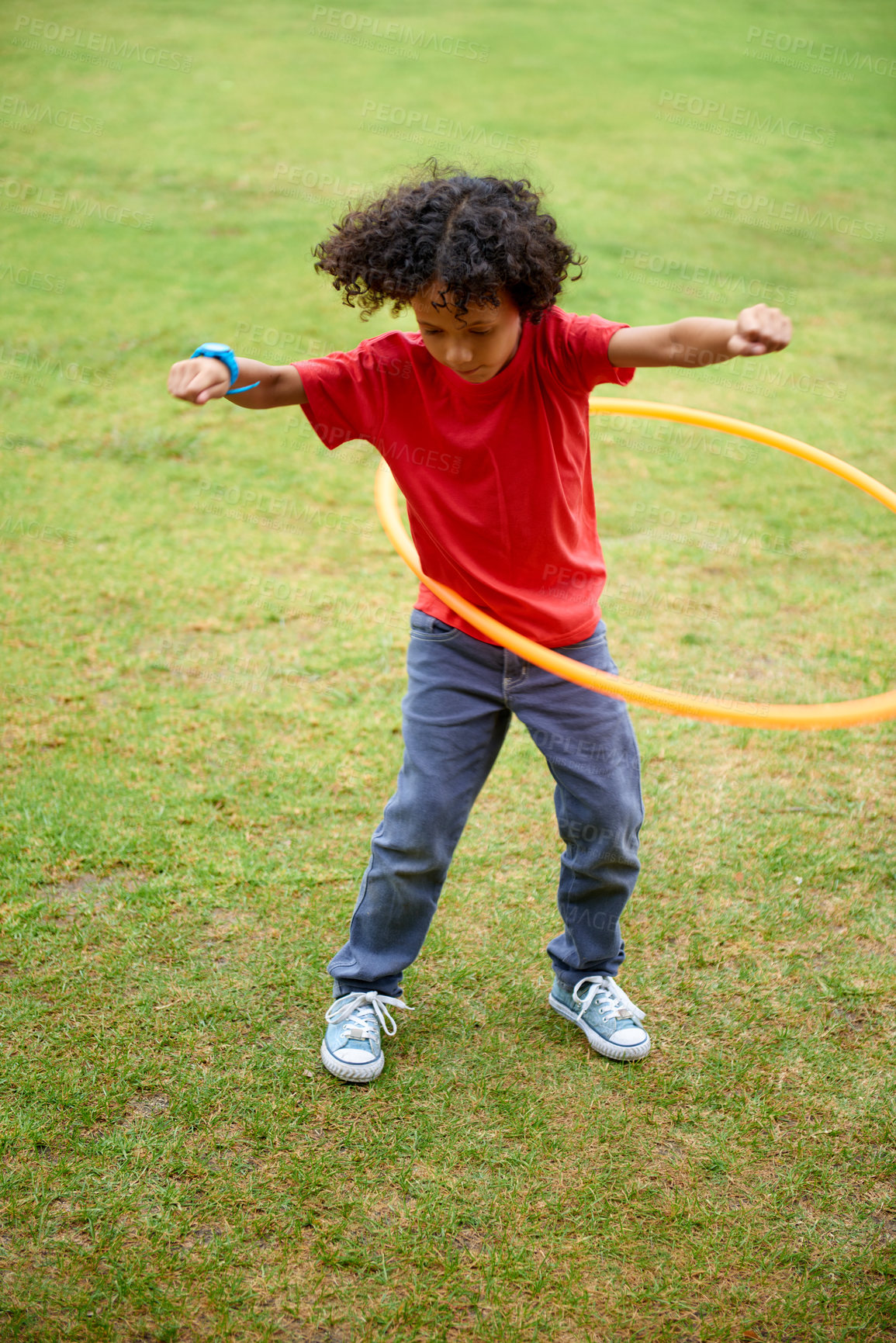 Buy stock photo Child, playing and hula hoop on field on holiday, green grass and sunshine with energy in city. Young boy, mexican and game on playground, summer break and leisure with wellness in urban town