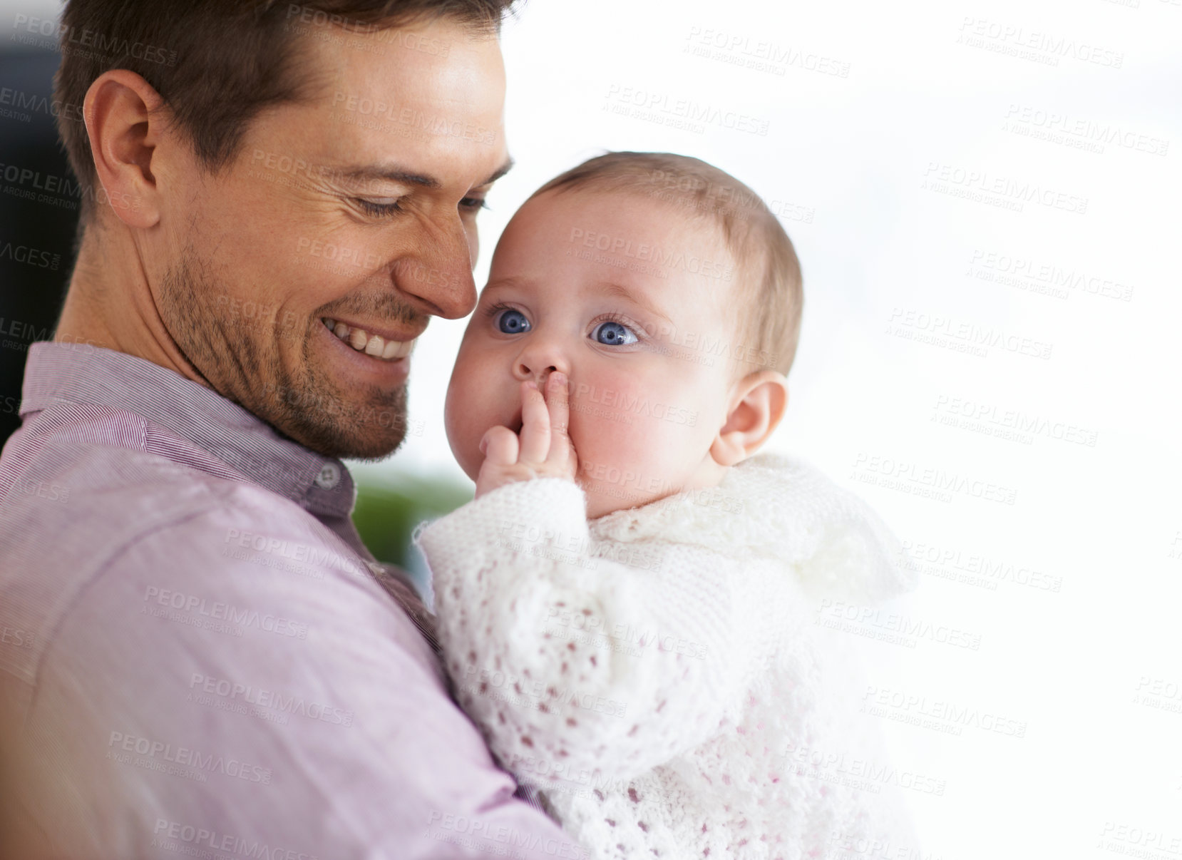 Buy stock photo Shot of a young father holding his adorable baby daughter and showing her affection