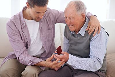 Buy stock photo Father, son and medal at home, smile and happy relationship in house. Family bonding, proud dad and child on sofa sitting together, elderly man and giving award at living room after retirement 