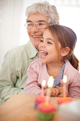 Buy stock photo Cupcakes, candles and girl with birthday, grandmother and gift with happiness, candy and home. Family, celebration and excited with humor or event with party or box with sweet, old woman or surprise
