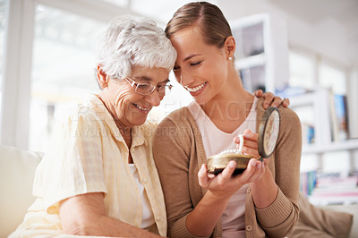 Buy stock photo Cropped shot of a senior woman giving her daughter a pearl necklace