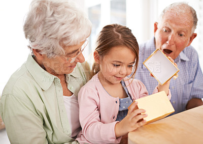 Buy stock photo Grandparents, child and open gift box, surprise for birthday with celebration for special event and family at home. Old people with young girl, unboxing and wow reaction for present with happiness