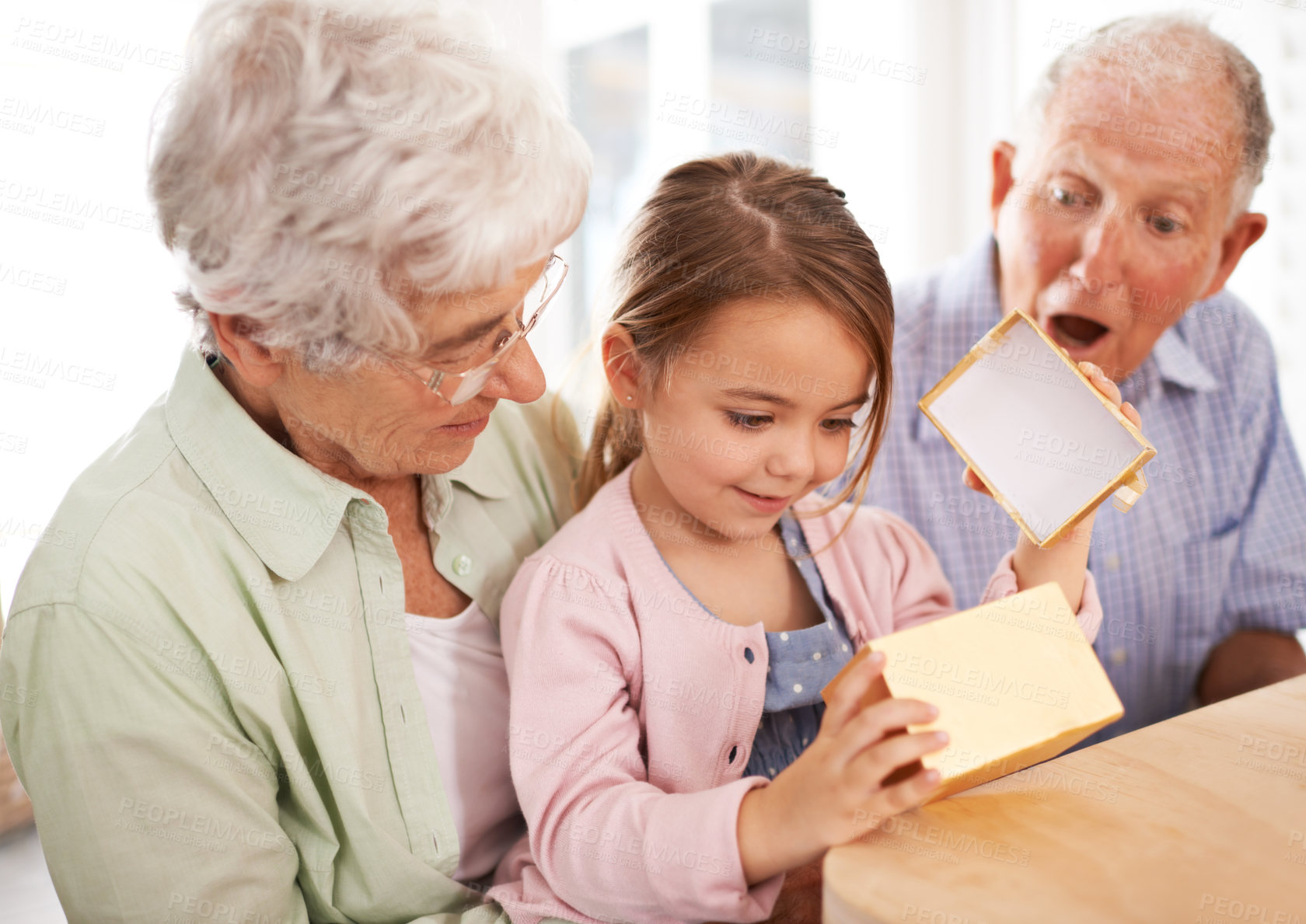 Buy stock photo Grandparents, child and open gift box, surprise for birthday with celebration for special event and family at home. Old people with young girl, unboxing and wow reaction for present with happiness