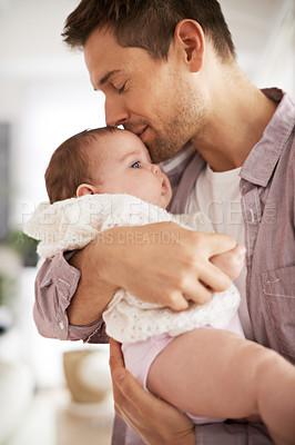 Buy stock photo Shot of a young father holding his adorable baby daughter and showing her affection