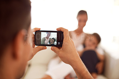 Buy stock photo Father taking a picture of family, home and screen with smartphone and social media in a lounge. Parents, mother and dad with daughter or child with memory and mobile user with digital app or network