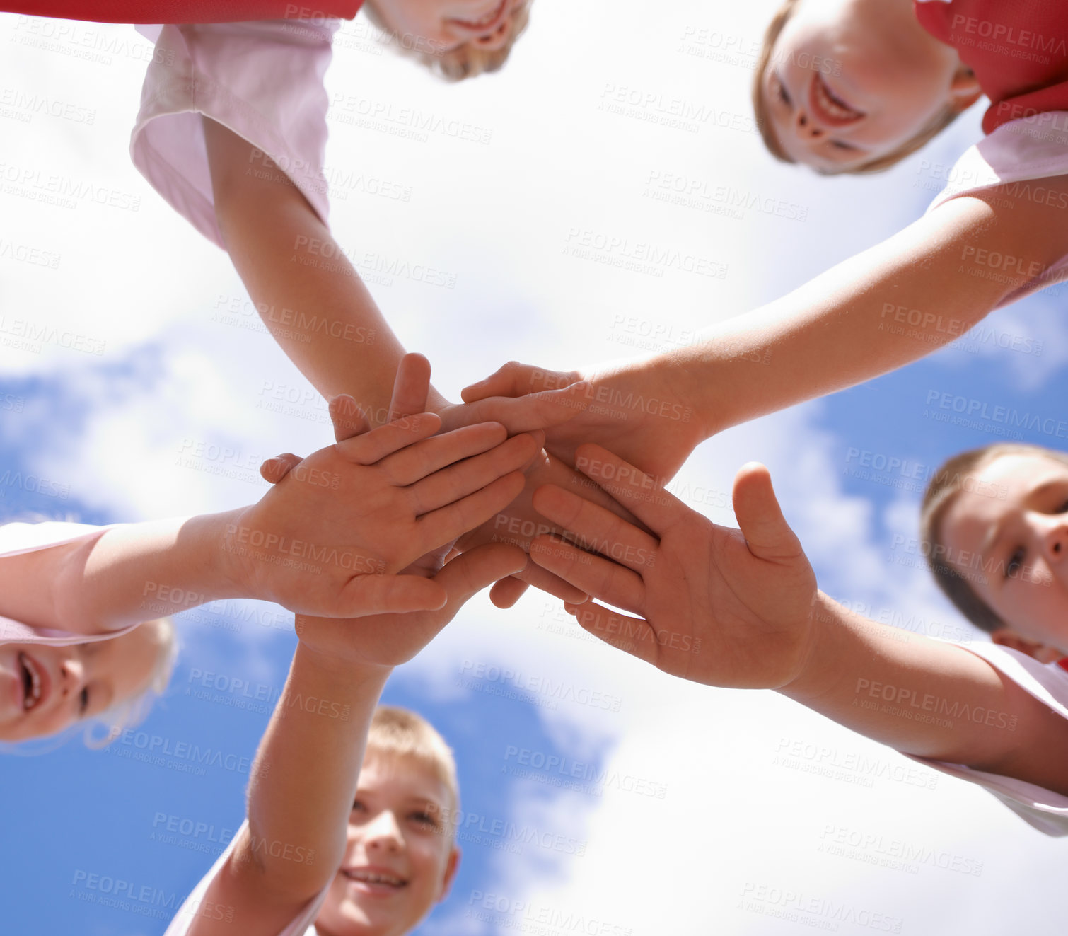 Buy stock photo Hands, collaboration and group of children on soccer team, below and huddle or support in circle. People, solidarity and stack or partnership and trust in community, together and sky background