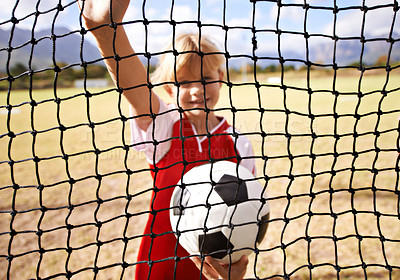 Buy stock photo Little girl, soccer player and ball on goal net, smile and happy for game, field and child. Outdoor, playful or sport for childhood, portrait and athlete for match, alone or outside on football pitch