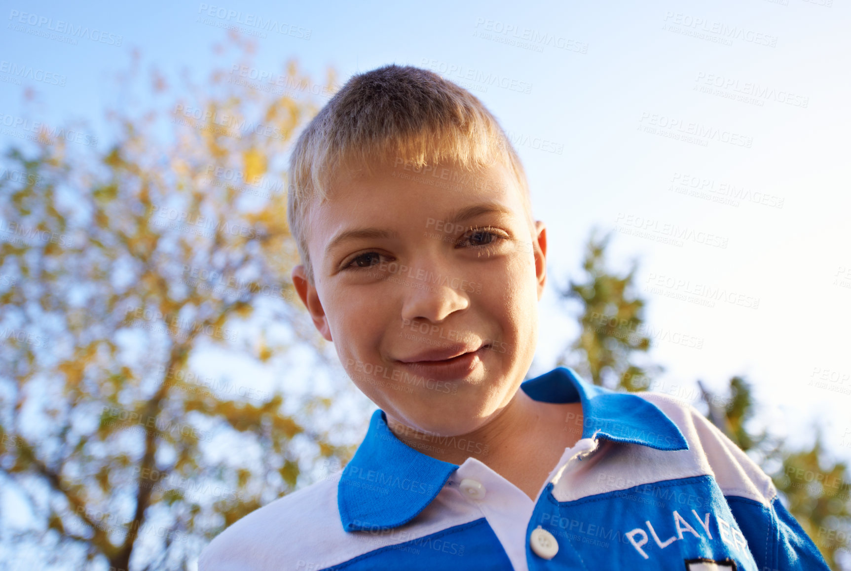 Buy stock photo Happy boy, portrait and playing in park with sunset for fun holiday, weekend or outdoor break in nature. Face of male person, kid or child smile on playground for childhood, activity or day outside