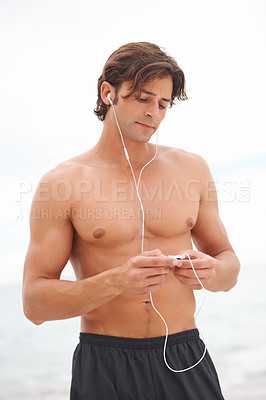 Buy stock photo Man, muscle and music on beach or exercise listening audio for sea air, playlist or running entertainment. Male person, radio and streaming song player or fresh ocean, weekend training or summer fun