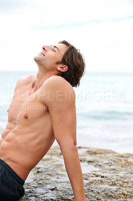 Buy stock photo Man, relax or shirtless at beach rock for holiday vacation fun, summer sunshine or travel. Male person, muscle or water for outdoor happy at sea or tropical journey trip, calm destination or swimwear