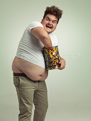 Buy stock photo Sweets, crazy and portrait of man in studio for luxury snacks, sugar and dessert in jar. Comic, funny facial expression and plus size person with glass container for unhealthy diet on background