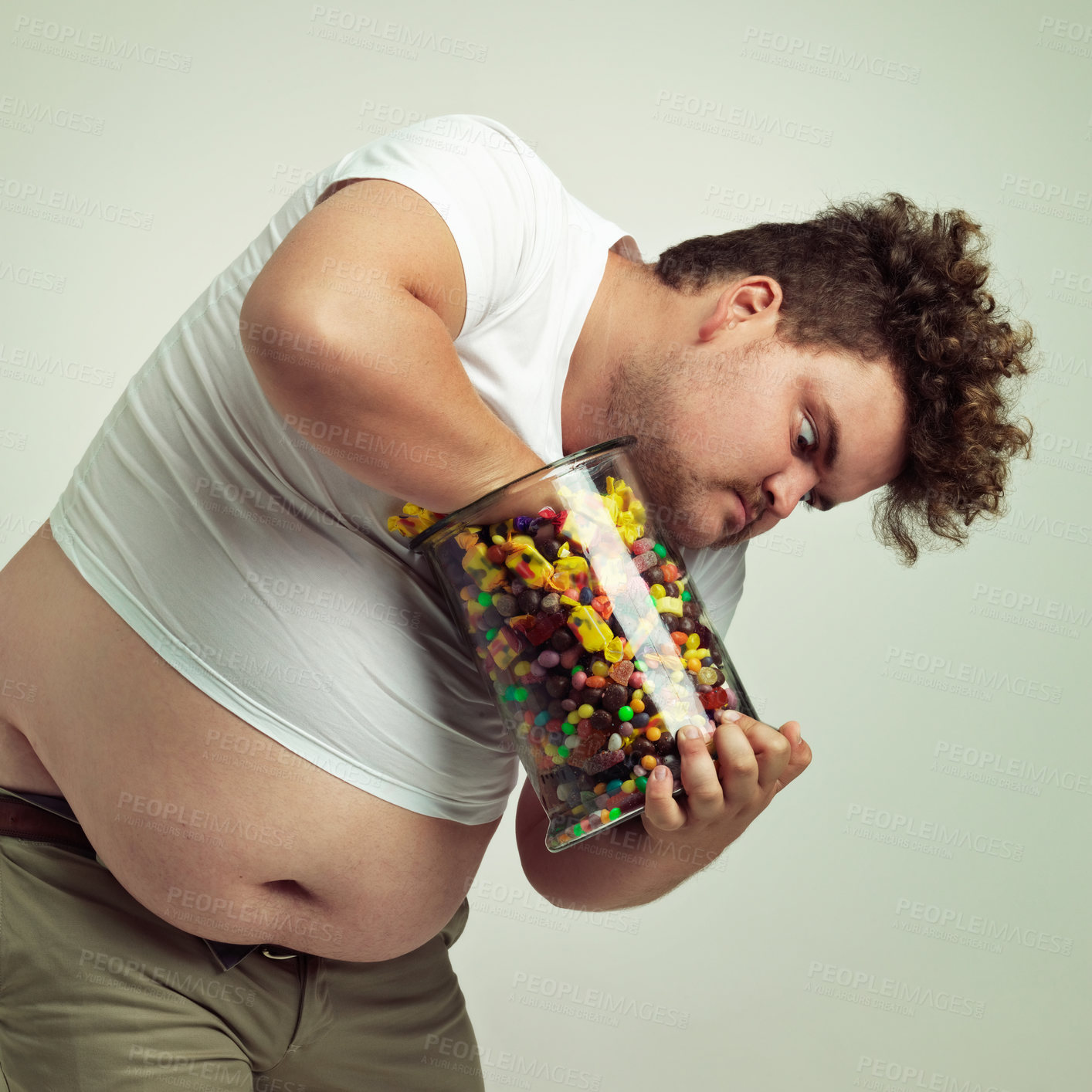 Buy stock photo Candy, jar and man in on studio background crazy for luxury snack, sweets or dessert in container. Comic, facial expression and isolated and plus size person with glass for unhealthy diet and sugar