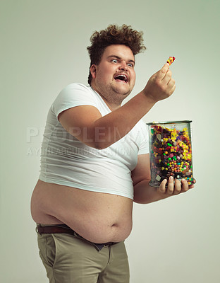 Buy stock photo Excited, man and happy with candy in studio for treat, snack and cheerful with unhealthy diet. Plus size, male person and jar of sweets with sugar food for happiness, enjoyment and satisfaction