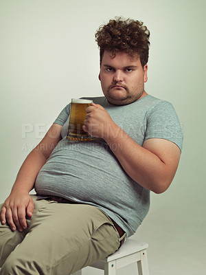 Buy stock photo Plus size, portrait and man with alcohol on stomach for unhealthy habit, serious and weight gain in studio of white background. Face, beer and male person by drink for tummy, calories and carbs