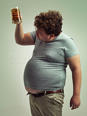 Buy stock photo Plus size, man and checking beer for unhealthy, habit and weight gain in studio of white background. Beverage, decision and male person with drink in hand for stomach, calories and carbs by mockup