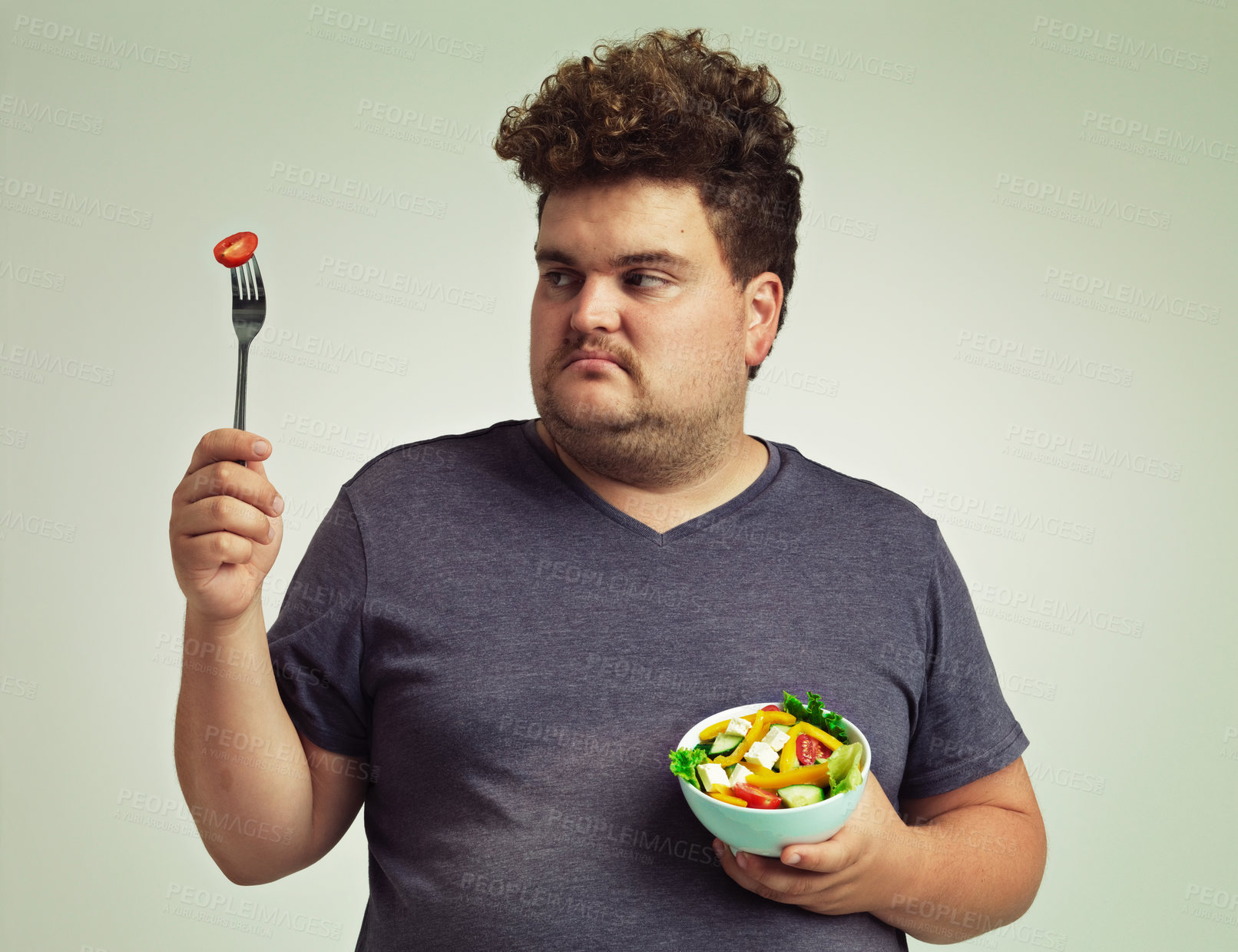 Buy stock photo Plus sized, man and unhappy with food for healthy diet, fork or bowl and salad for wellness on studio background. Male person, detox and lose weight for health, eating disorder and nutrition 