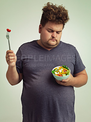 Buy stock photo Unhappy, man and salad for diet with healthy food, fork or bowl and vegetables for wellness on studio background. Plus size person, fresh meal and lose weight for health, eating disorder or nutrition